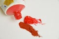 Tube of cadmium red oil paint with blobs of red and brown paint