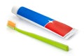 A tube of red and blue toothpaste and a toothbrush on a white background. Full depth of field