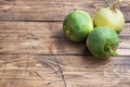 Tubers of raw green radish on a wooden background