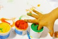 Tubes with colorful bright colors with baby`s fingers stuck inside