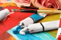 Tubes of colorful oil paints and brushes on canvas with abstract painting Royalty Free Stock Photo