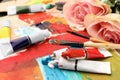 Tubes of colorful oil paints, flowers and brushes on canvas Royalty Free Stock Photo