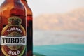 Tuborg beer bottle by the sea, background Royalty Free Stock Photo