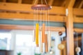 tubular wind chimes made of copper hanging from a wooden beam Royalty Free Stock Photo