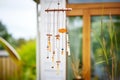 tubular wind chimes made of copper hanging from a wooden beam Royalty Free Stock Photo