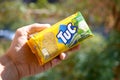 Tuc snack pack in male hand on a green trees background