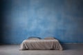 Tucked in twin bed isolated against a grunge wall backdrop Royalty Free Stock Photo