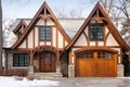 Tudor style family house exterior with gable roof and timber framing. Wooden garage doors in home cottage. Created with generative