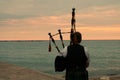 Female Bagpiper on the Pier at Sunset Royalty Free Stock Photo