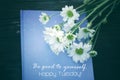 Tuesday quote - Be good to yourself. Happy Tuesday. Text message on blue book with flowers on vintage background.