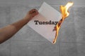 Tuesday word text on fire with burning paper