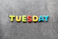 Tuesday word written with colorful letters on granite stone background