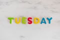 Tuesday word written with colorful letters on white marble stone background Royalty Free Stock Photo