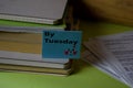 By Tuesday write on a sticky note isolated on Office Desk. Business Document concept Royalty Free Stock Photo