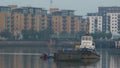 Tug and barges on the Thames at dawn.