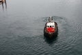 A tug boat drags the boat dock lines from a cruise ship to the dock to be tied up Royalty Free Stock Photo