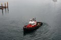 A tug boat drags the boat dock lines from a cruise ship to the dock to be tied up Royalty Free Stock Photo