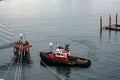 A tug boat drags the boat dock lines from a cruise ship to the dock to be tied up. tug boat drags the boat dock lines from a Royalty Free Stock Photo