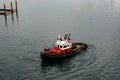 A tug boat drags the boat dock lines from a cruise ship to the dock to be tied up Royalty Free Stock Photo