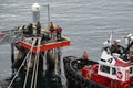 A tug boat drags the boat dock lines from a cruise ship to the dock to be tied up Royalty Free Stock Photo