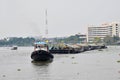 Tug boat drags sand barge on Chao Phraya river