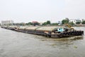 Tug boat drags sand barge on Chao Phraya river