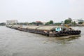 Tug boat drags sand barge on Chao Phraya river, Bangkok