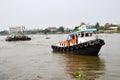 Tug boat drags sand barge on Chao Phraya river, Bangkok