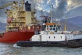 tug boat enter with a ship in marina di carrara harbour Royalty Free Stock Photo