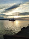 A tug boat moving upriver in sunset with dramatic clouds wide angle Royalty Free Stock Photo