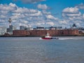 A tug boat passes the front of the Albert Dock warehouse buildings on the historic UNESCO listed Liverpool waterfront