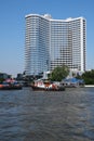 A tug boat passes in front of 5-star luxury hotel Royalty Free Stock Photo