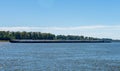 Tug boat pusher behind freight barges loaded with grain on Mississippi River Royalty Free Stock Photo