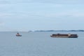 Tug boat tows bulk cargo lighter barge along Singapore strait