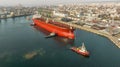 Aerial view of tug boats assisting big oil tanker. Large oil tanker ship enters the port escorted by tugboats Royalty Free Stock Photo