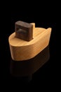 Tug boot made from Oak and walnut on black reflecting surface Royalty Free Stock Photo