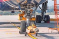 TUG carrier for huge airplane, trailer front landing gear pushback aerodrome tractor with airplane on the runway in airport