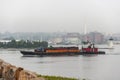 Tug pushing barge across New Bedford harbor on foggy morning Royalty Free Stock Photo