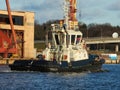 Tug vessel entering port, industrial background. Rural marine landscape Royalty Free Stock Photo