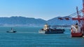 Tugboat assist a container ship on the way out of the harbor Royalty Free Stock Photo