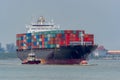 Tugboats help a large container ship. Royalty Free Stock Photo