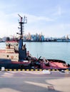 Tugboat assist on a pier in the harbor, cargo sea port over the sea, Floating cargo crane, Granary elevators, harbor, boats and Royalty Free Stock Photo