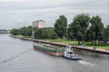 Tugboat with cargo at Dutch Amsterdam-Rijn canal near city Utrecht
