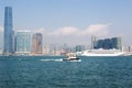 The tugboat cheerfully cuts through the Victoria BaysPanorama of the Kowloon waterfront and cruise ship