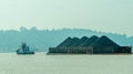 Tugboat drag barge full of coal crossing Mahakam River, Samarinda, in the morning. Royalty Free Stock Photo