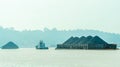 Tugboat drag barge full of coal crossing Mahakam River, Samarinda, in the morning. Royalty Free Stock Photo