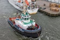 Tugboat in Dutch harbor IJmuiden supporting ferry to English Newcastle