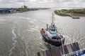 Tugboat in Dutch harbor IJmuiden supporting ferry to English Newcastle