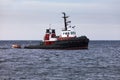 Tugboat floating in wait on calm ocean at anchor