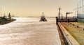 Tugboat leaves the harbor basin in the late afternoon and plunges into the open sea, backlight shot before sunset Royalty Free Stock Photo